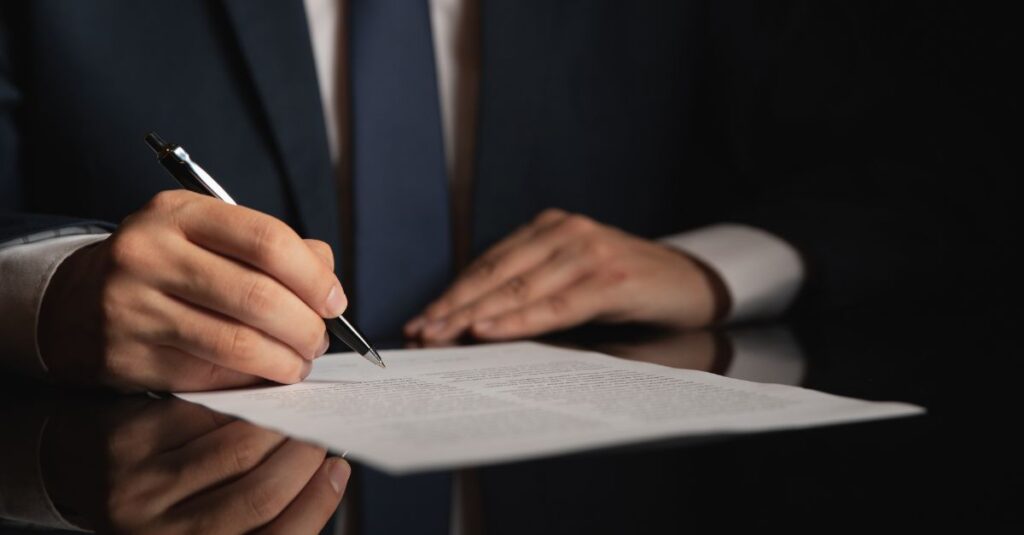 man signing a document